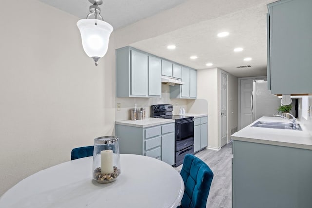 8805 Clearbrook Trl Unit A, Austin, TX 78729 - kitchen with black electric range, under cabinet range hood, light wood-style floors, recessed lighting, and freestanding refrigerator