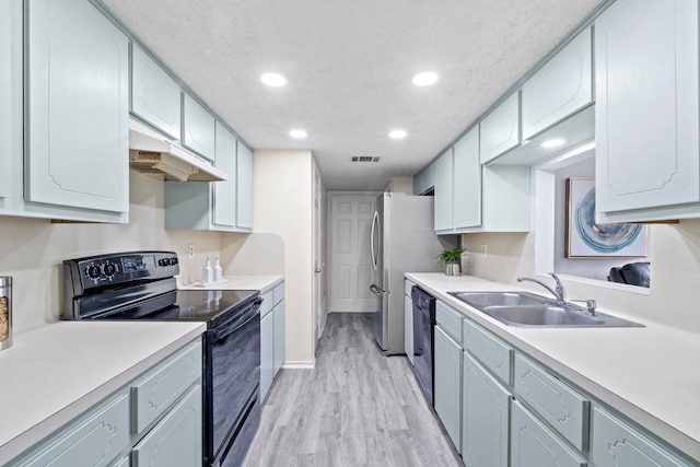 8805 Clearbrook Trl Unit A, Austin, TX 78729 - kitchen with black appliances, a sink, under cabinet range hood, recessed lighting, and light wood-style flooring