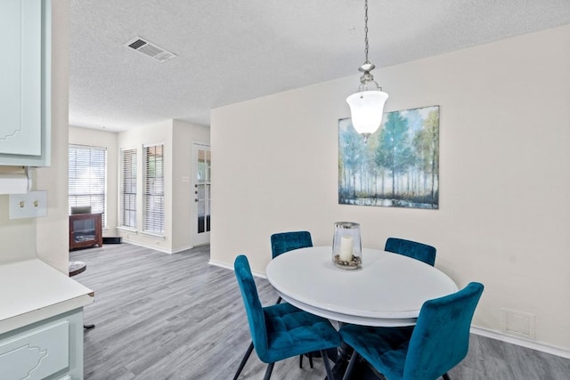8805 Clearbrook Trl Unit A, Austin, TX 78729 - dining area with a textured ceiling, wood finished floors, and baseboards