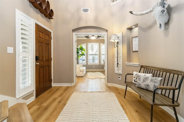 foyer with light wood-style floors and baseboards