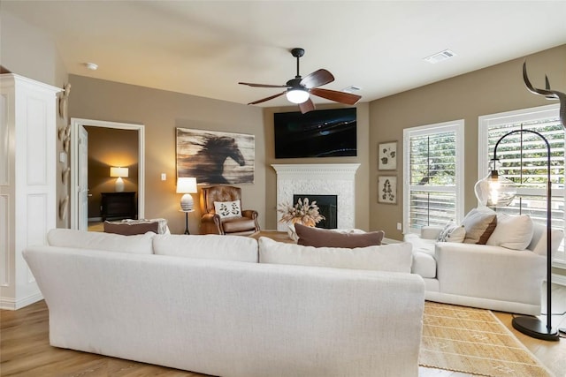 living room with ceiling fan, wood finished floors, and a fireplace