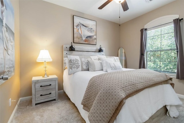 bedroom featuring light carpet, baseboards, and ceiling fan