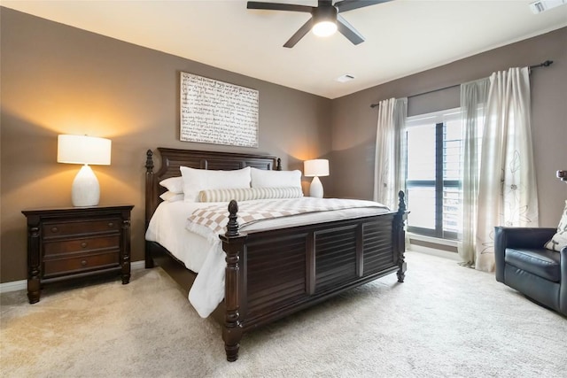 bedroom featuring light carpet, a ceiling fan, and baseboards