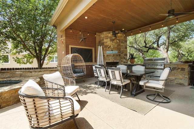 view of patio / terrace featuring an outdoor stone fireplace, ceiling fan, an outdoor kitchen, and grilling area