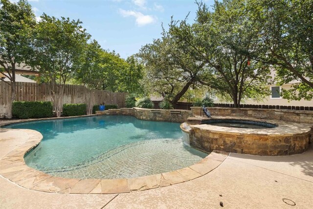 view of pool featuring a fenced backyard and a pool with connected hot tub