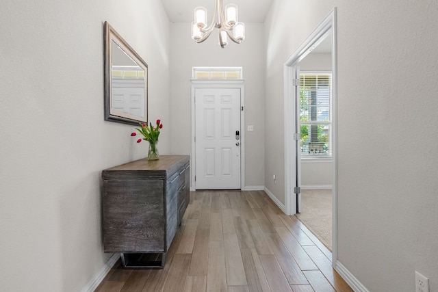 12709 Twisted Root Dr, Manchaca, TX 78652 - foyer entrance featuring a chandelier, light wood-type flooring, and baseboards