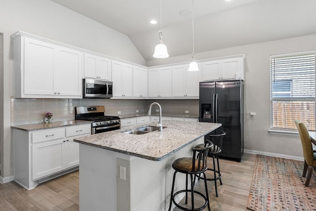 12709 Twisted Root Dr, Manchaca, TX 78652 - kitchen with appliances with stainless steel finishes, a sink, light wood-type flooring, decorative backsplash, and white cabinets