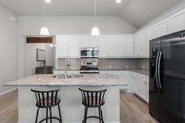 12709 Twisted Root Dr, Manchaca, TX 78652 - kitchen with appliances with stainless steel finishes, a sink, light wood-type flooring, backsplash, and lofted ceiling