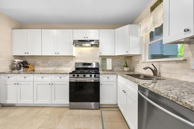 kitchen featuring appliances with stainless steel finishes, under cabinet range hood, a sink, and white cabinetry