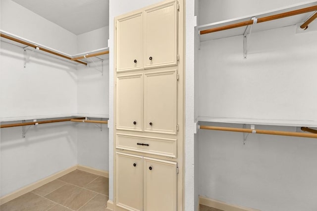 spacious closet with light tile patterned floors