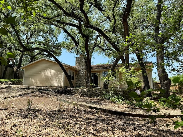 view of front of home with a chimney and fence