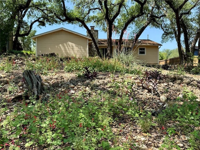 back of property featuring fence and a chimney