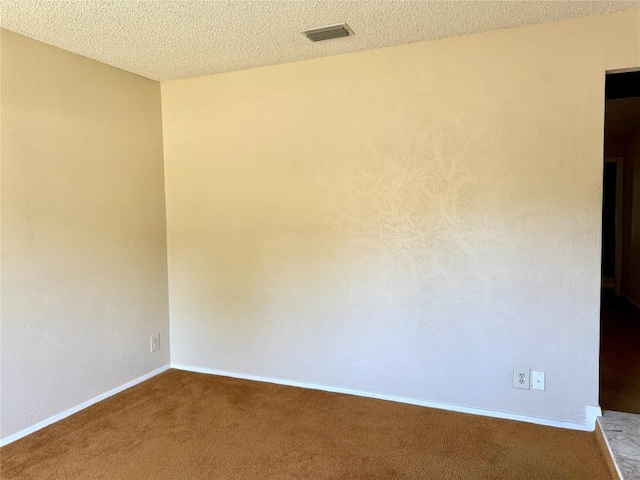 unfurnished room featuring carpet, baseboards, and a textured ceiling