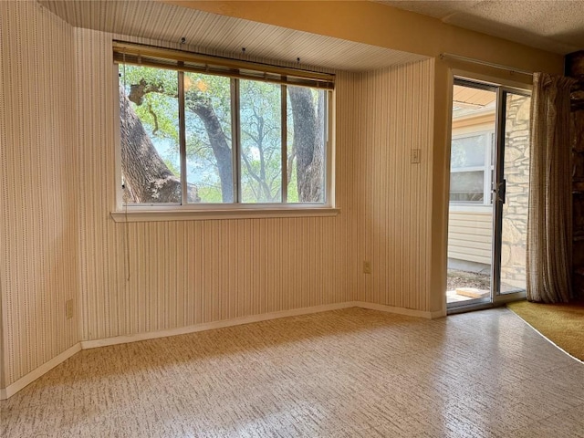 empty room with baseboards and wooden walls