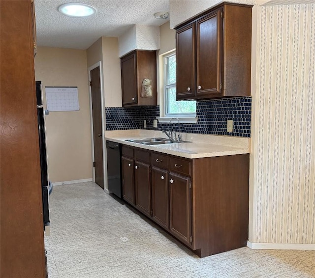 kitchen with black dishwasher, baseboards, light countertops, a sink, and decorative backsplash