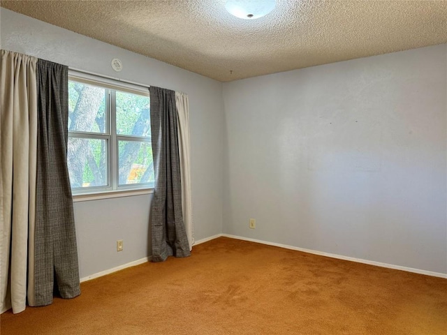 carpeted spare room with a textured ceiling and baseboards
