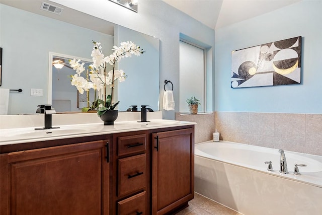 full bath with double vanity, tile patterned flooring, and a garden tub