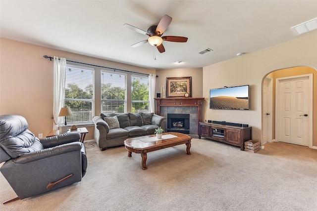 201 Tulip Trail Bnd, Cedar Park, TX 78613 - living area with ceiling fan, light carpet, a tile fireplace, arched walkways, and baseboards
