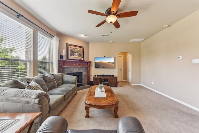 201 Tulip Trail Bnd, Cedar Park, TX 78613 - living room with arched walkways, baseboards, ceiling fan, light carpet, and a tile fireplace