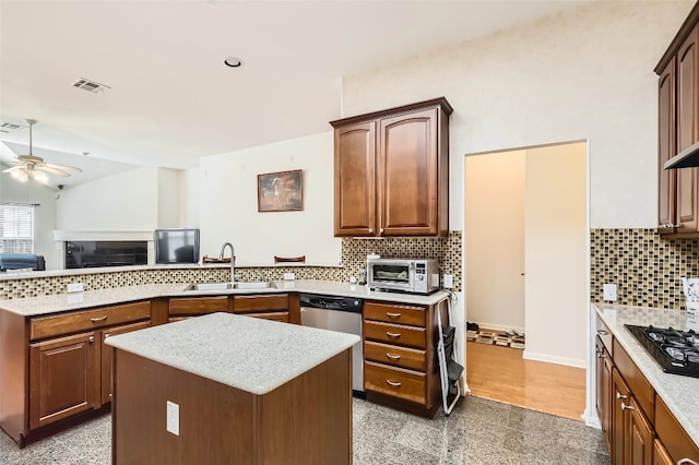 kitchen featuring a sink, ceiling fan, a peninsula, black gas cooktop, and dishwasher