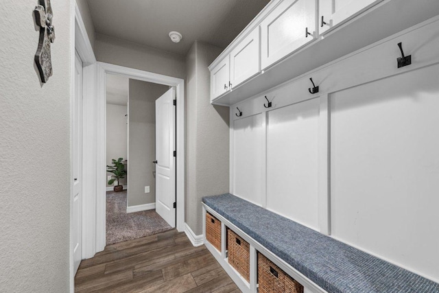 mudroom with dark wood-style flooring and baseboards