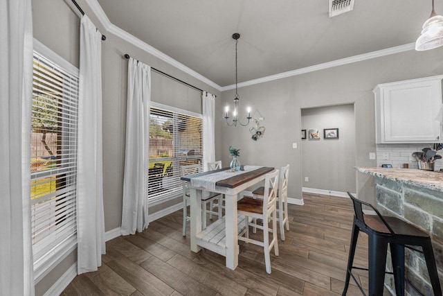dining area featuring ornamental molding, a chandelier, baseboards, and dark wood-style floors