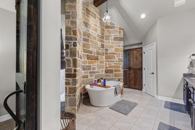 bathroom featuring a soaking tub, vanity, baseboards, and tile patterned flooring