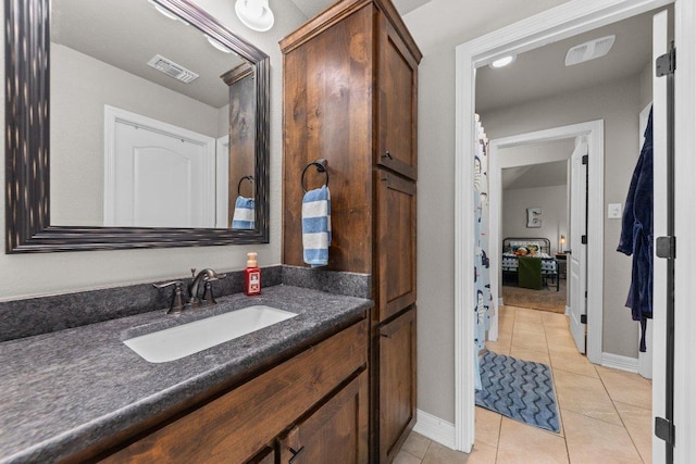 bathroom with tile patterned flooring, vanity, and baseboards