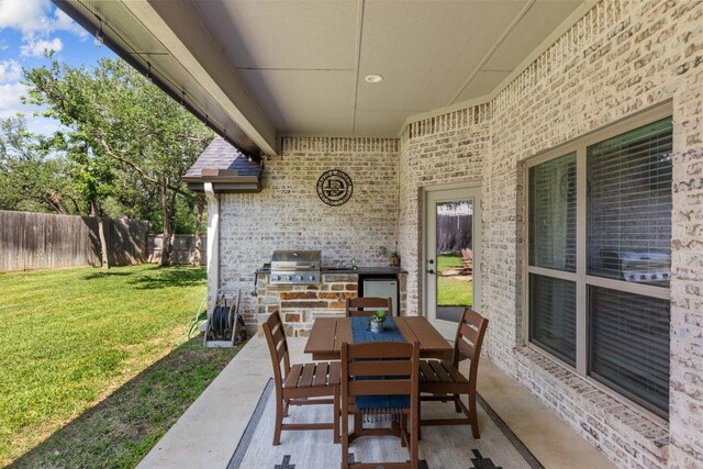view of patio featuring exterior kitchen, area for grilling, and outdoor dining space