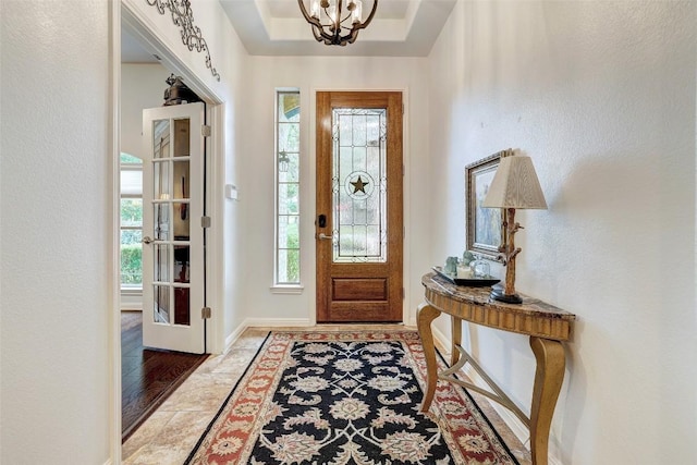 entrance foyer featuring a chandelier and baseboards