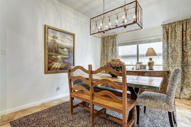 dining area featuring a chandelier and baseboards