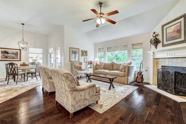 living room featuring dark wood-style flooring, plenty of natural light, a ceiling fan, a tile fireplace, and high vaulted ceiling