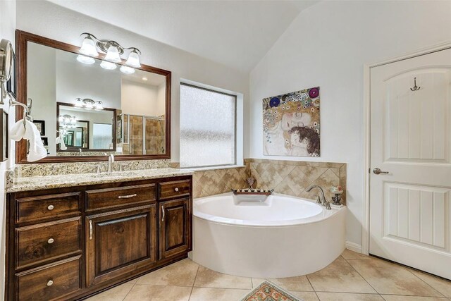 bathroom with lofted ceiling, tile patterned flooring, a garden tub, vanity, and a shower