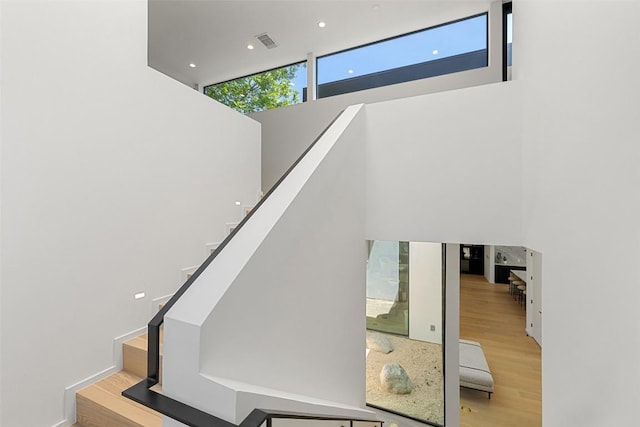 2502 Barhill Dr, Austin, TX 78704 - stairway featuring a towering ceiling, wood finished floors, and recessed lighting