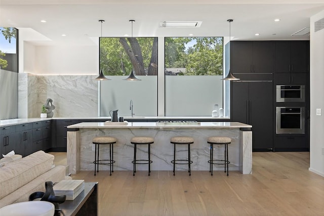 2502 Barhill Dr, Austin, TX 78704 - kitchen featuring oven, modern cabinets, a kitchen breakfast bar, and recessed lighting