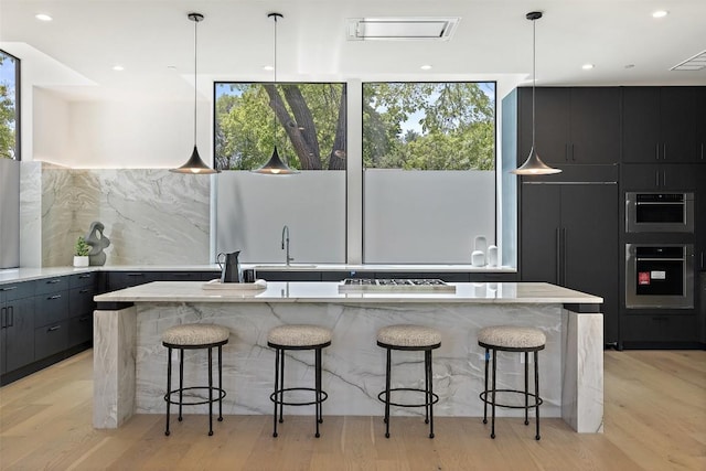 2502 Barhill Dr, Austin, TX 78704 - kitchen with appliances with stainless steel finishes, modern cabinets, a breakfast bar, light wood-style flooring, and recessed lighting