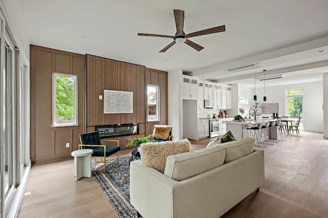 living area with ceiling fan and light wood-style flooring