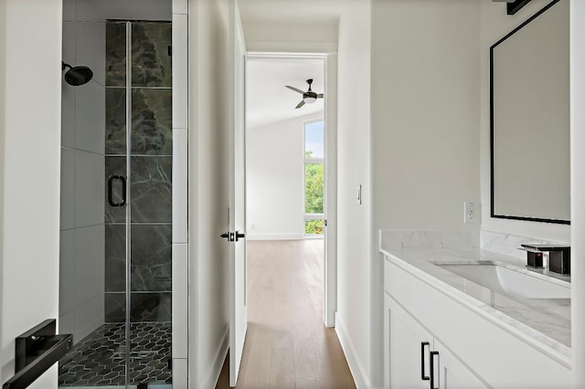 bathroom featuring a shower stall, vanity, wood finished floors, and ceiling fan