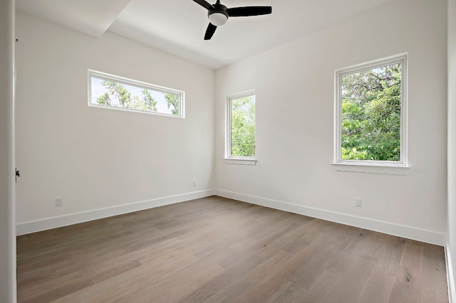 empty room with baseboards, wood finished floors, and ceiling fan