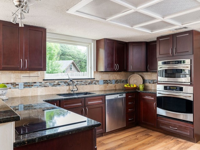 504 Ridgecrest Rd, Georgetown, TX 78628 - kitchen featuring stainless steel appliances, light wood-style floors, backsplash, dark stone counters, and a textured ceiling
