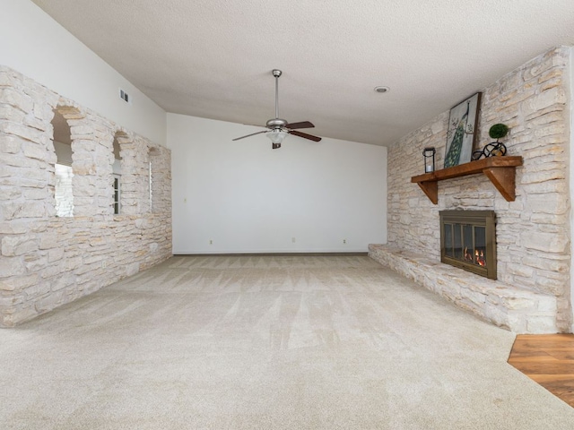 504 Ridgecrest Rd, Georgetown, TX 78628 - unfurnished living room featuring carpet floors, a ceiling fan, a fireplace, and a textured ceiling