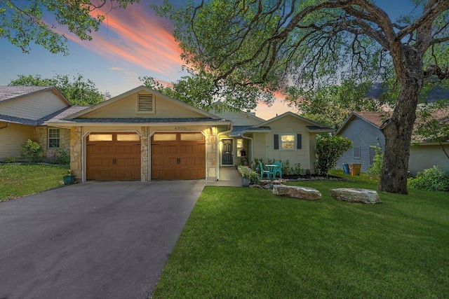 4806 Transit Cir, Austin, TX 78727 - ranch-style home featuring an attached garage, stone siding, driveway, and a lawn
