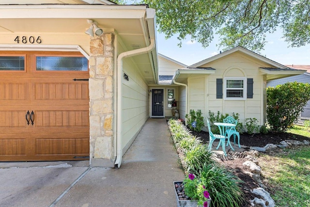 4806 Transit Cir, Austin, TX 78727 - doorway to property featuring stone siding and an attached garage