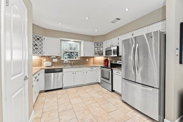 4806 Transit Cir, Austin, TX 78727 - kitchen with stainless steel appliances, backsplash, open shelves, white cabinets, and recessed lighting