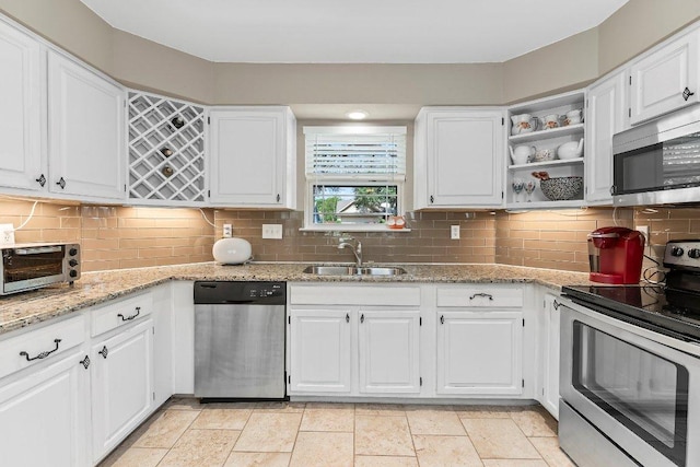 4806 Transit Cir, Austin, TX 78727 - kitchen with appliances with stainless steel finishes, a sink, white cabinetry, and light stone countertops