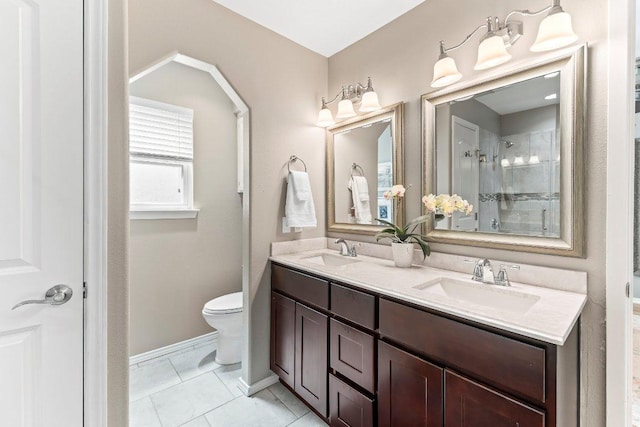 4806 Transit Cir, Austin, TX 78727 - bathroom featuring double vanity, toilet, a tile shower, baseboards, and tile patterned floors