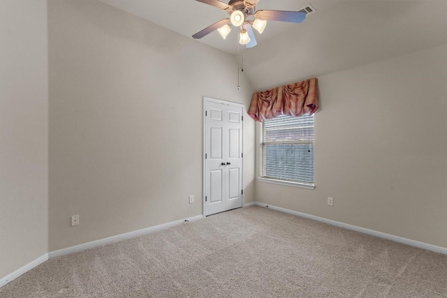 spare room with light colored carpet, ceiling fan, baseboards, and vaulted ceiling