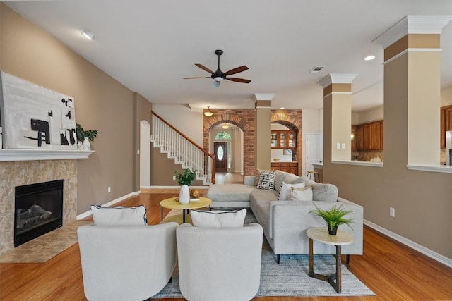 living room with ceiling fan, stairway, light wood finished floors, ornate columns, and recessed lighting