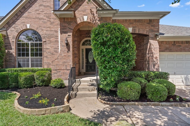 view of exterior entry with brick siding and an attached garage
