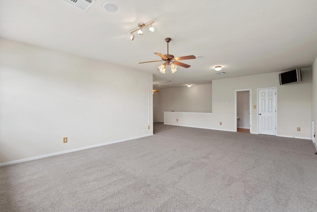 carpeted spare room featuring ceiling fan and baseboards